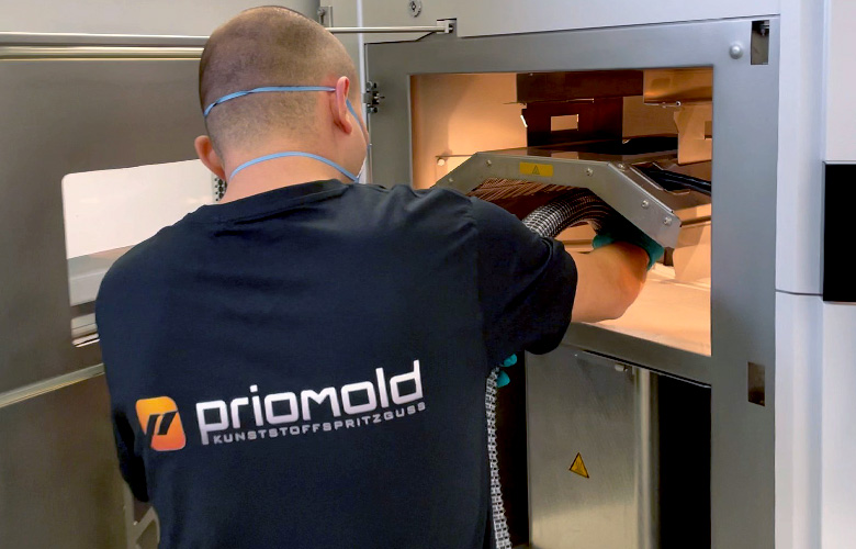 priomold employee working on an SLS 3D printer