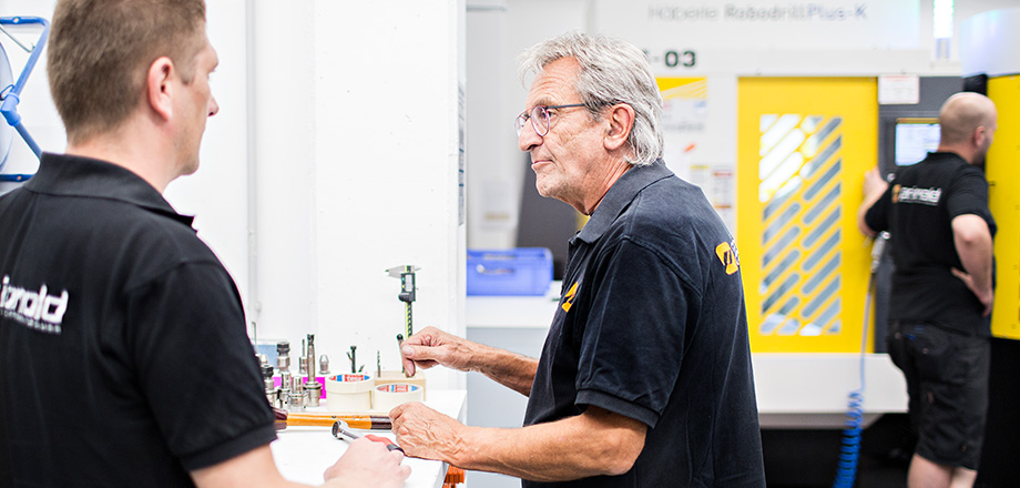 Two Priomold employees talking in a workshop